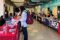 A student speaks with ASU staff members at a resource fair on campus
