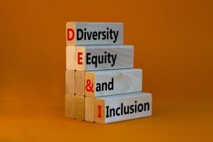 A stack of four wooden blocks with the words “Diversity, Equity and Inclusion” against an orange background.