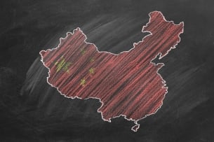 A chalk country map of China, colored in red with yellow stars to match the Chinese flag, drawn on a blackboard.