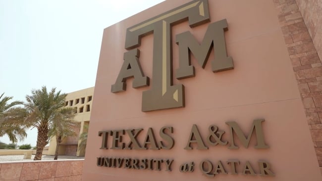 A brown building facade that reads Texas A&M University at Qatar