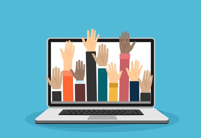 Hands of people of various races raised up from a laptop keyboard