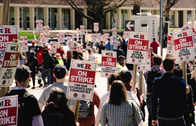 A photograph of striking Rutgers University workers holding signs.