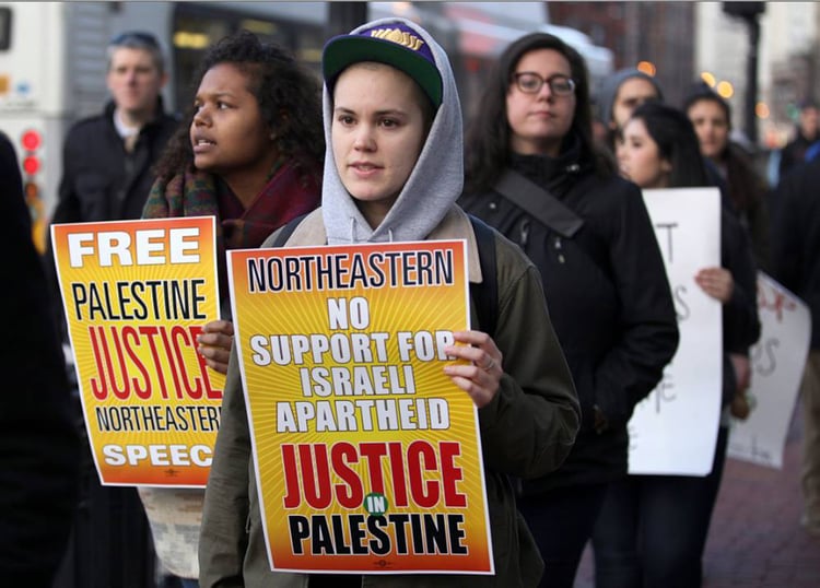 Protesters at Northeastern University holding signs reading "Free Palestine," "No support for Israeli apartheid."