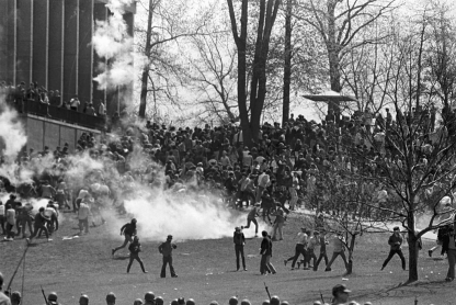 A black-and-white image of members of the National Guard firing tear gas at student protestors at Kent State University on May 4, 1970.