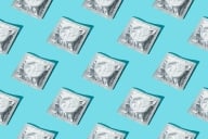 A pattern of silver condom wrappers on a blue background