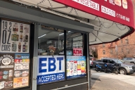 A sign saying "EBT accepted" sits in the window of a Queens, N.Y., bodega.