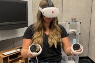 A student uses IUPUI's VR headset and joysticks to practice public speaking.