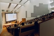 Students sit in a large lecture hall