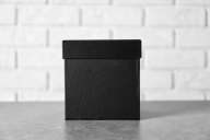 A black box on a table against the background of a white wall.