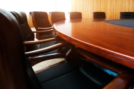 A photo of chairs around a sleek conference table.