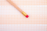 A number 2 pencil lies on a blank standardized test answer sheet filled with multiple choice bubbles.