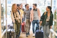 Group of university college tourists walking inside a hotel with suitcases