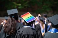 A student wears a pride flag on their graduation mortar board.