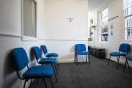 An empty waiting room with blue chairs