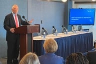 Ted Mitchell, president of the American Council on Education, stands at a podium in front of a group.