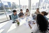 Multiracial group of people working at a boardroom table on a business presentation