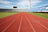 An empty running track inside a stadium.