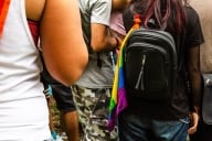 Teenager with backpack and a LGBTQ+ flag