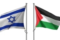 Two flagpoles, one with an Israeli flag and one with a Palestinian flag, stand next to one another.