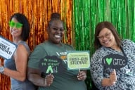 Students pose in a photo booth, holding signs that say "First-gen student," "I make a difference" and "I heart GTCC."