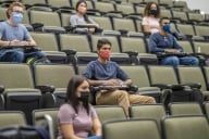 Students in a lecture hall wearing masks