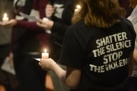 Students at a candlelight vigil, one wearing a shirt that says "Shatter the Silence, Stop the Violence"