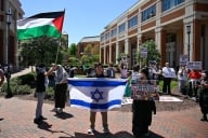 One student holding an Israeli flag amid students waving Palestinian flags at the University of North Carolina at Charlotte.