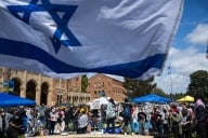 UCLA Jewish students waving Israeli flags counterprotest fellow students in their Palestinian solidarity camp on their Westwood campus on Thursday, April 25, 2024. College protests around the country are seeking their schools divest from Israel over the Israel-Hamas war. 