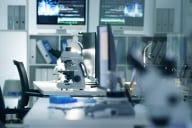 A photo of an empty biomedical laboratory with a microscope and other equipment.