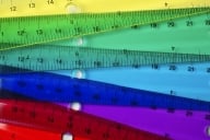 Rulers of different colors overlap with one another, creating a rainbow-like effect.