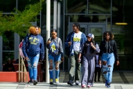 A group of five students, some wearing North Carolina A&T shirts and sweatshirts, walk on campus. 