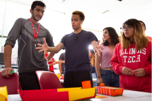 Four students at the Illinois Institute of Technology complete a colorful paper construction project.