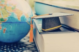 A mortarboard next to a globe.