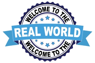 A seal that reads "Welcome to the Real World."