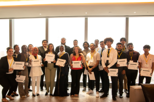 CUNY apprentices smile for a photo holding certificates of completion.