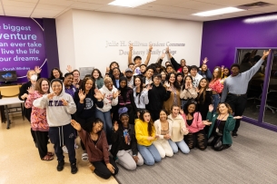 Dougherty Family College students smile with their hands outstretched.