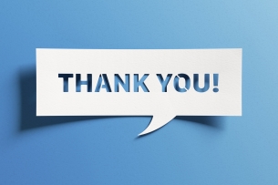 White text bubble–style sign on a blue background says, "Thank you!"