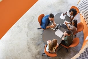 Overhead view of a group of young entrepreneurs working together in a start-up business meeting