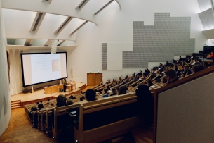 Students sit in a large lecture hall