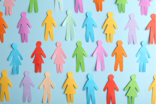 A collection of human cut-out paper figures of varying colors and genders placed flat against a blue background, illustrating the concept of diversity.