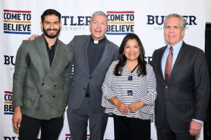 Four people, three men and a woman. One of the men is wearing a priest's collar.