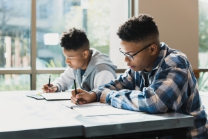 Two young men take an exam