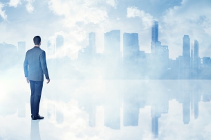 Man in suit stands in front of a painted city skyline