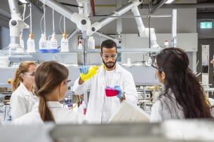 Five scientists conduct an experiment in a science lab