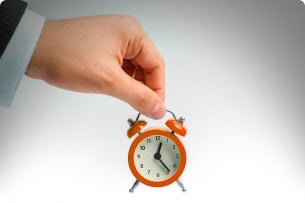 A photograph of someone holding a small clock.