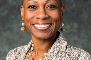 A professional headshot of Antoinette “Bonnie” Candia-Bailey, a Black woman, who smiles widely.