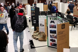 Students and faculty at Tennessee Tech wander through student poster boards in a multipurpose room