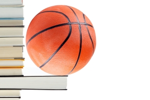 Basketball perches on book protruding horizontally from a stack of books