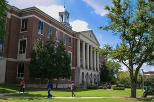 Students walk in front of an academic building at Tennessee State University on a sunny day.