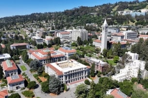 An aerial drone view of the University of California, Berkeley campus shows buildings and trees near a hillside